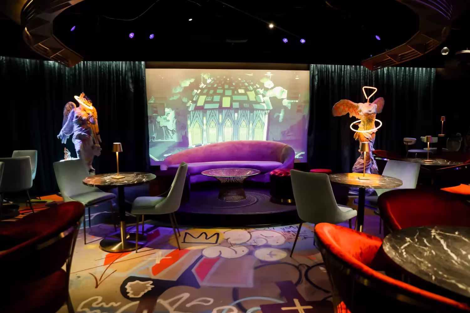 Colorful suede couches are surrounded by sculptures in Meow Wolf Denver Sips with a Z