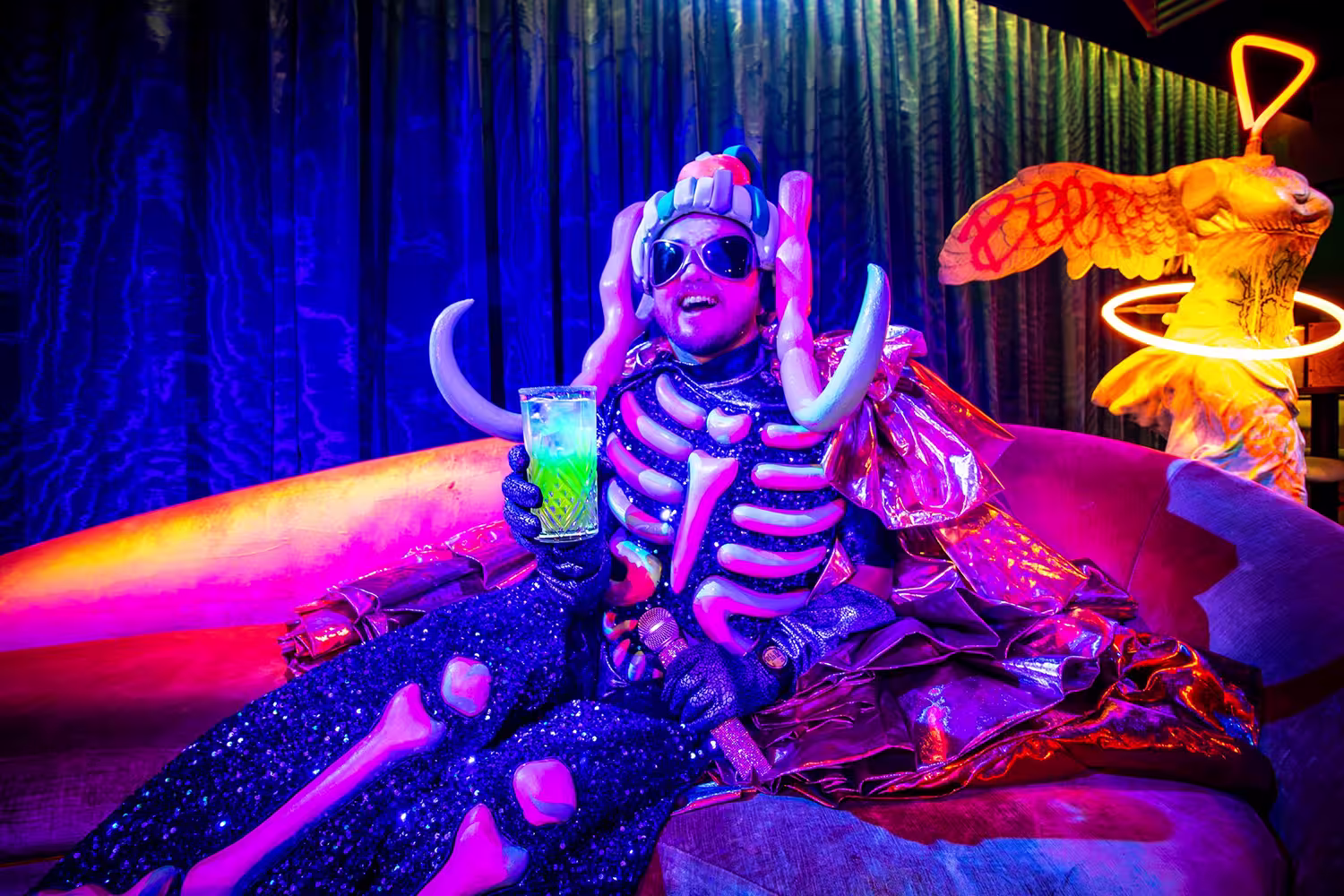 A person in a bony creature costume at Sips with a Z