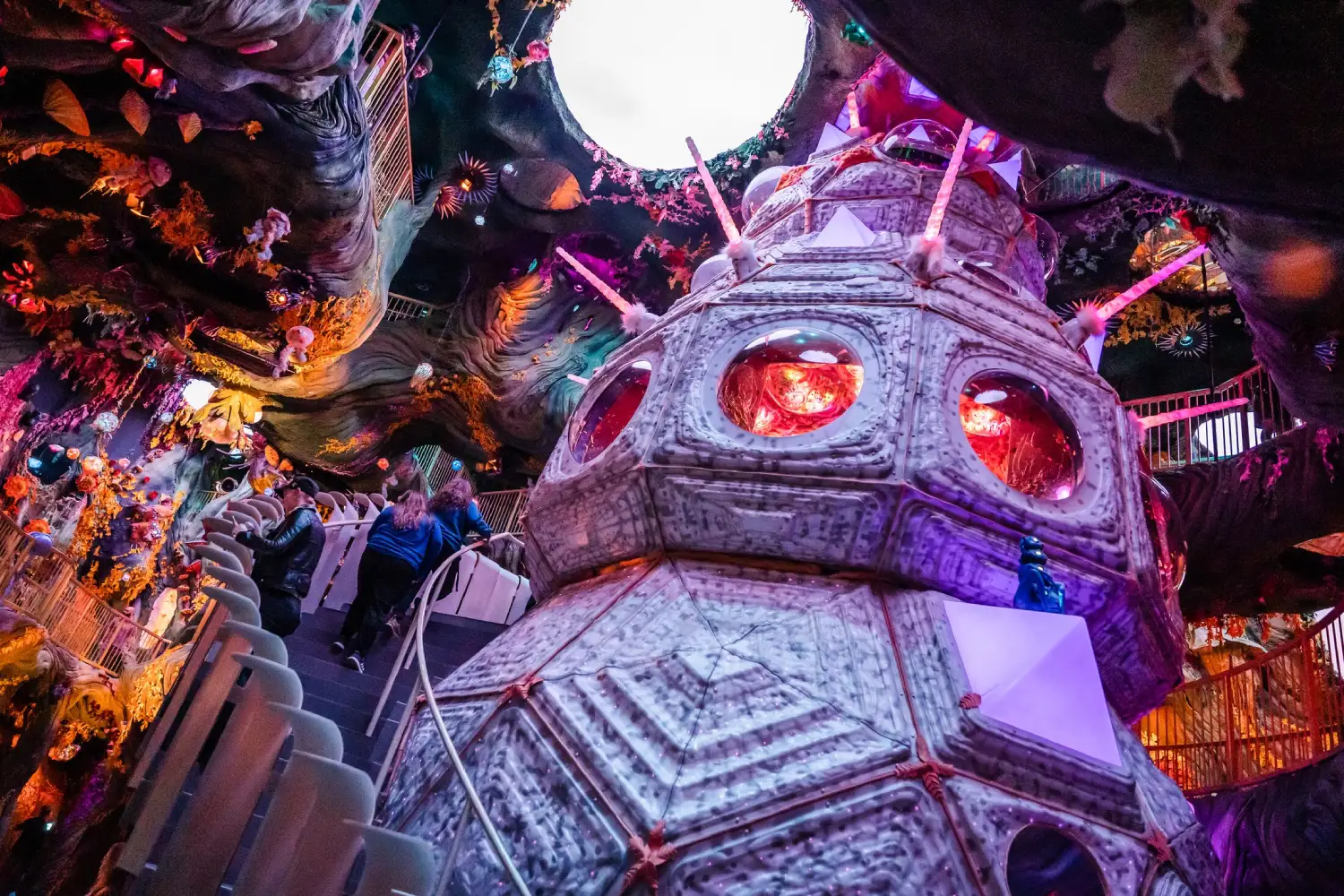 Towering bioluminescent pod inside Numina at Meow Wolf Denver, ringed by surreal tree balconies, signature immersive art experience in Colorado.
