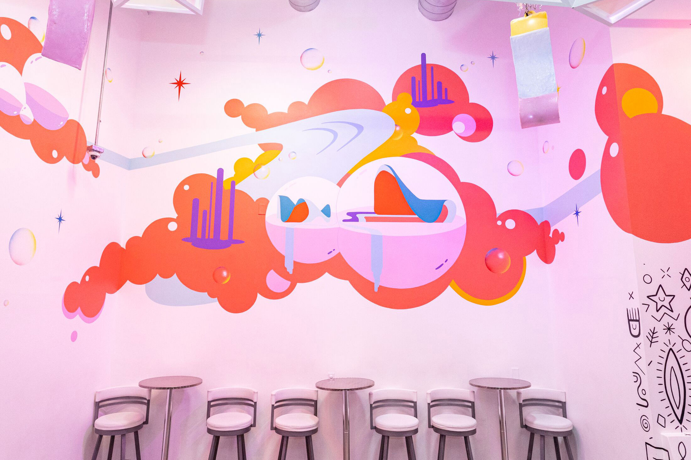 pink and red clouds over a bar table and stools at Float Bar