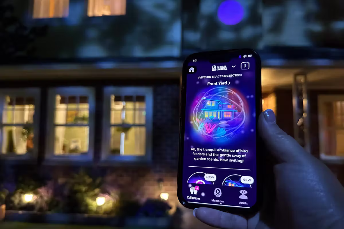people crowded around a phone with the Meow Wolf app on it