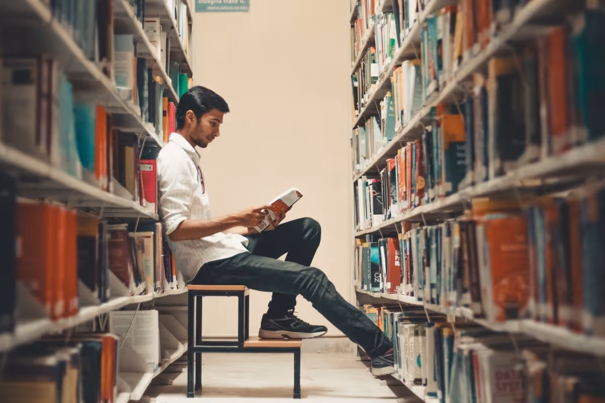 A man reading in a library. 