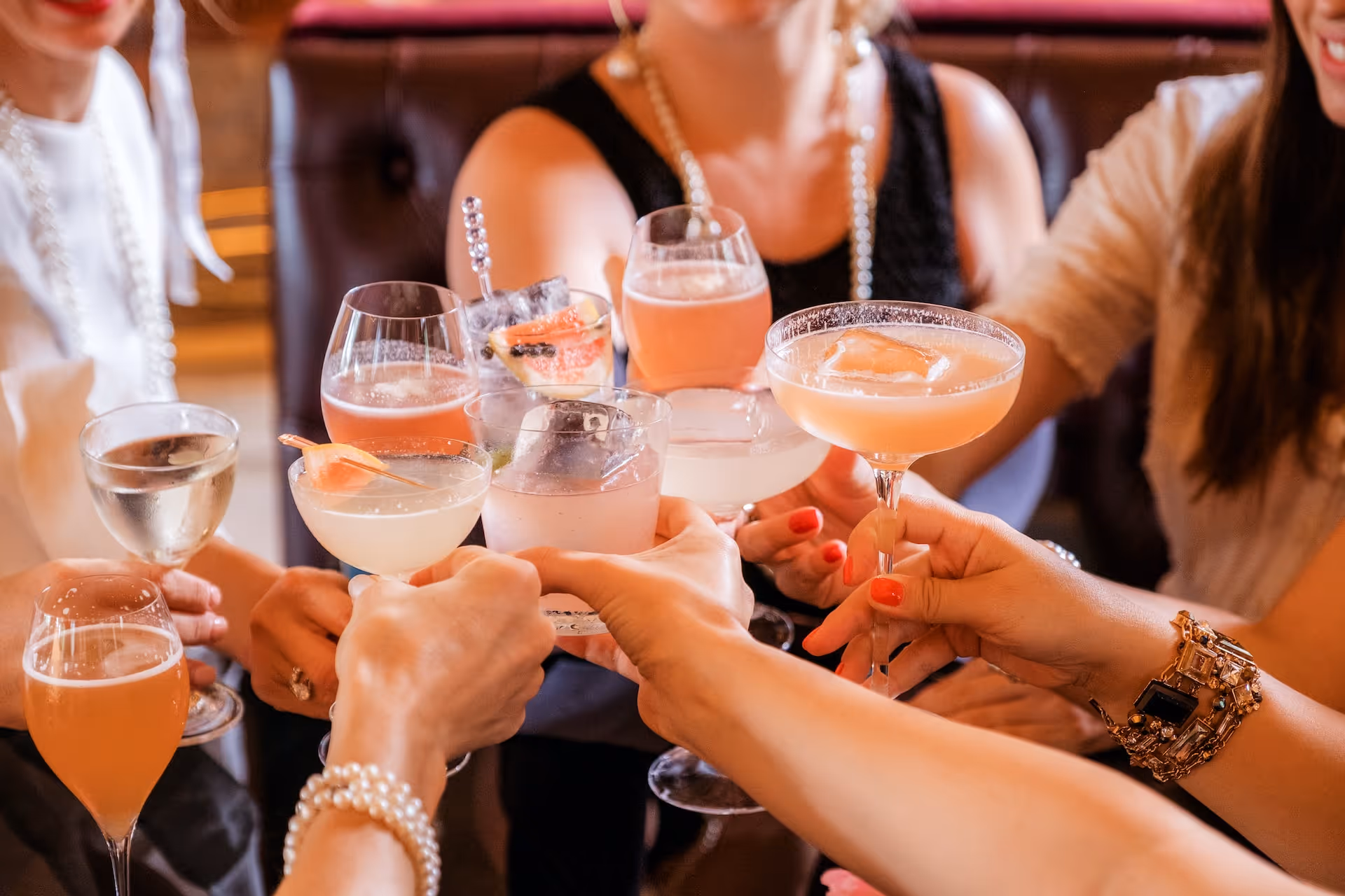 group of people toasting with herbal tonic cocktails