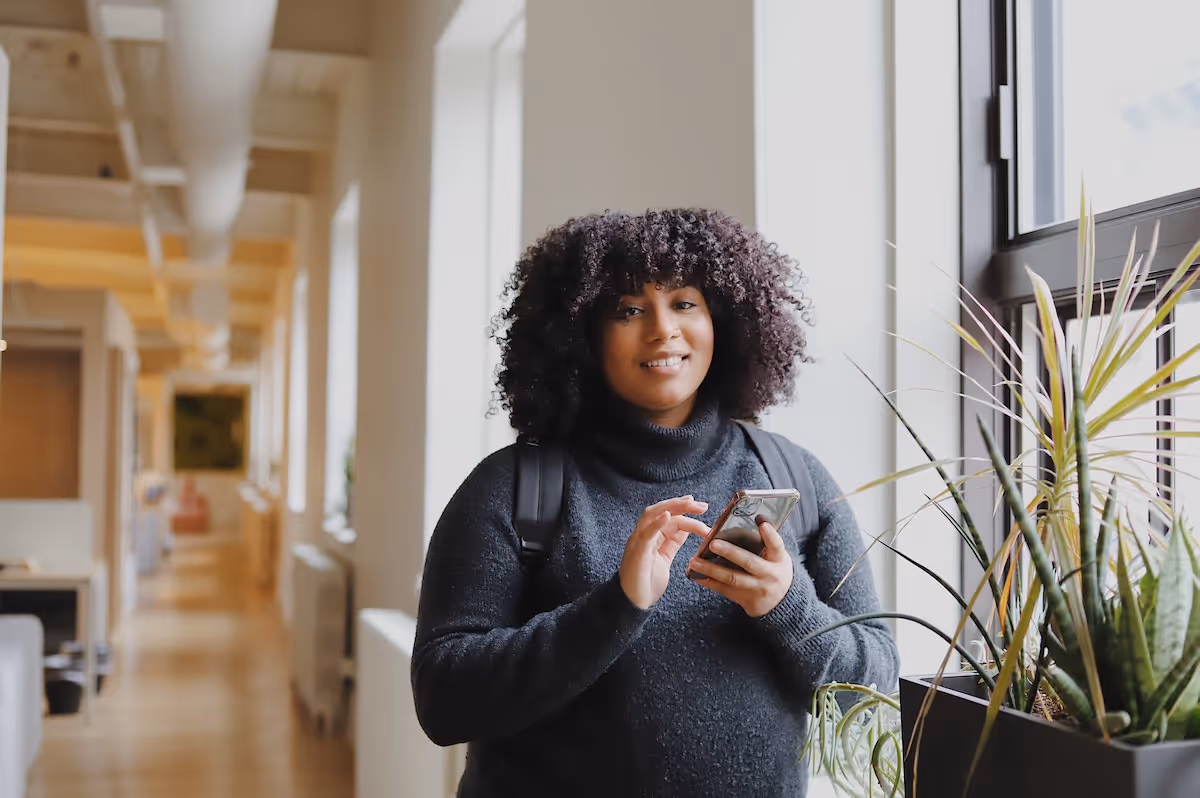 Woman in gray sweater looking at phone