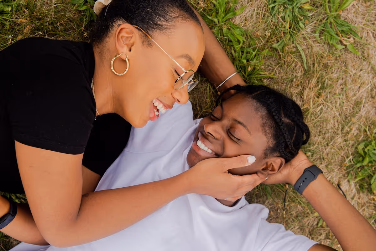 Couple lays on the ground, woman caressing her partners face