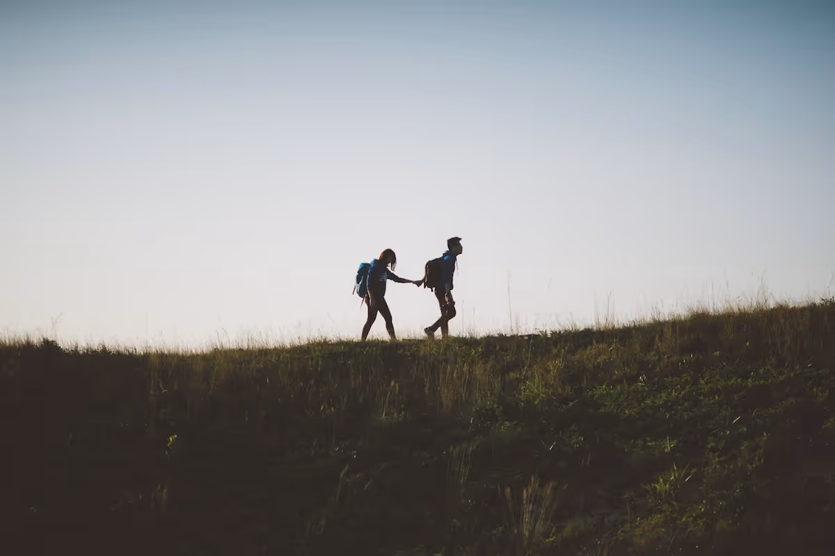 Couple hiking up a hill together