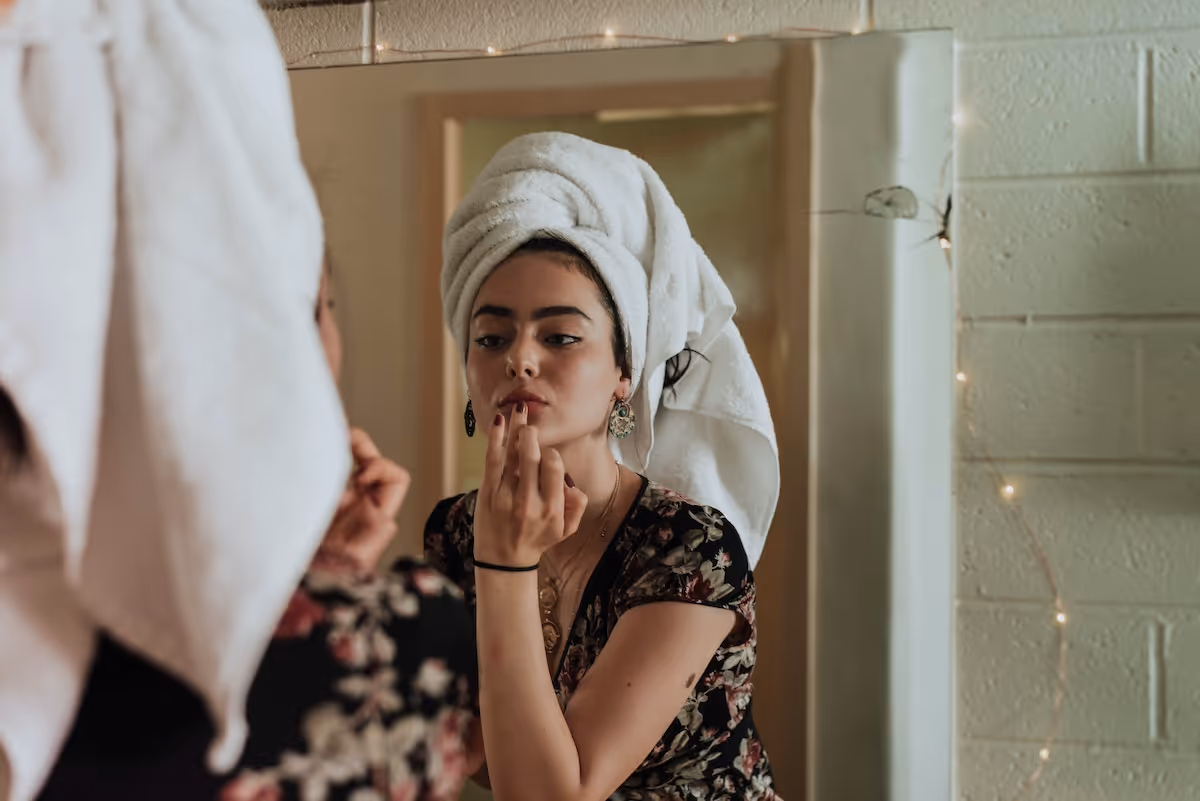 Woman doing her makeup in the mirror
