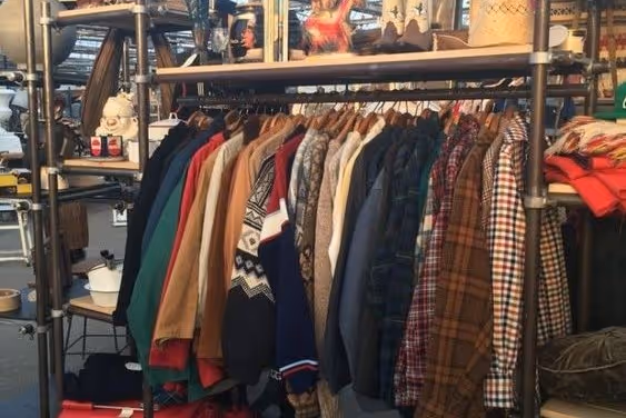  A rack of thrifted clothes in a thrift store.
