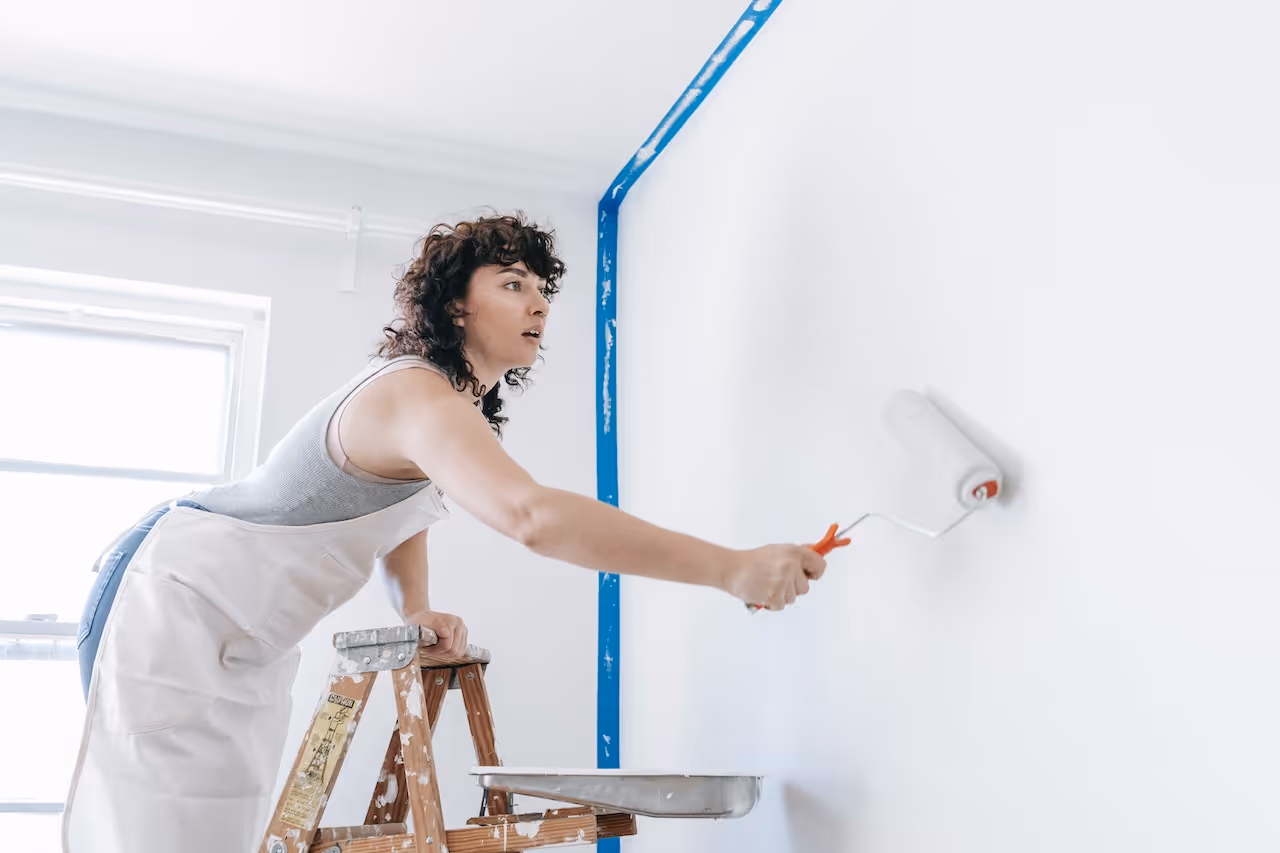 woman painting a wall in her home