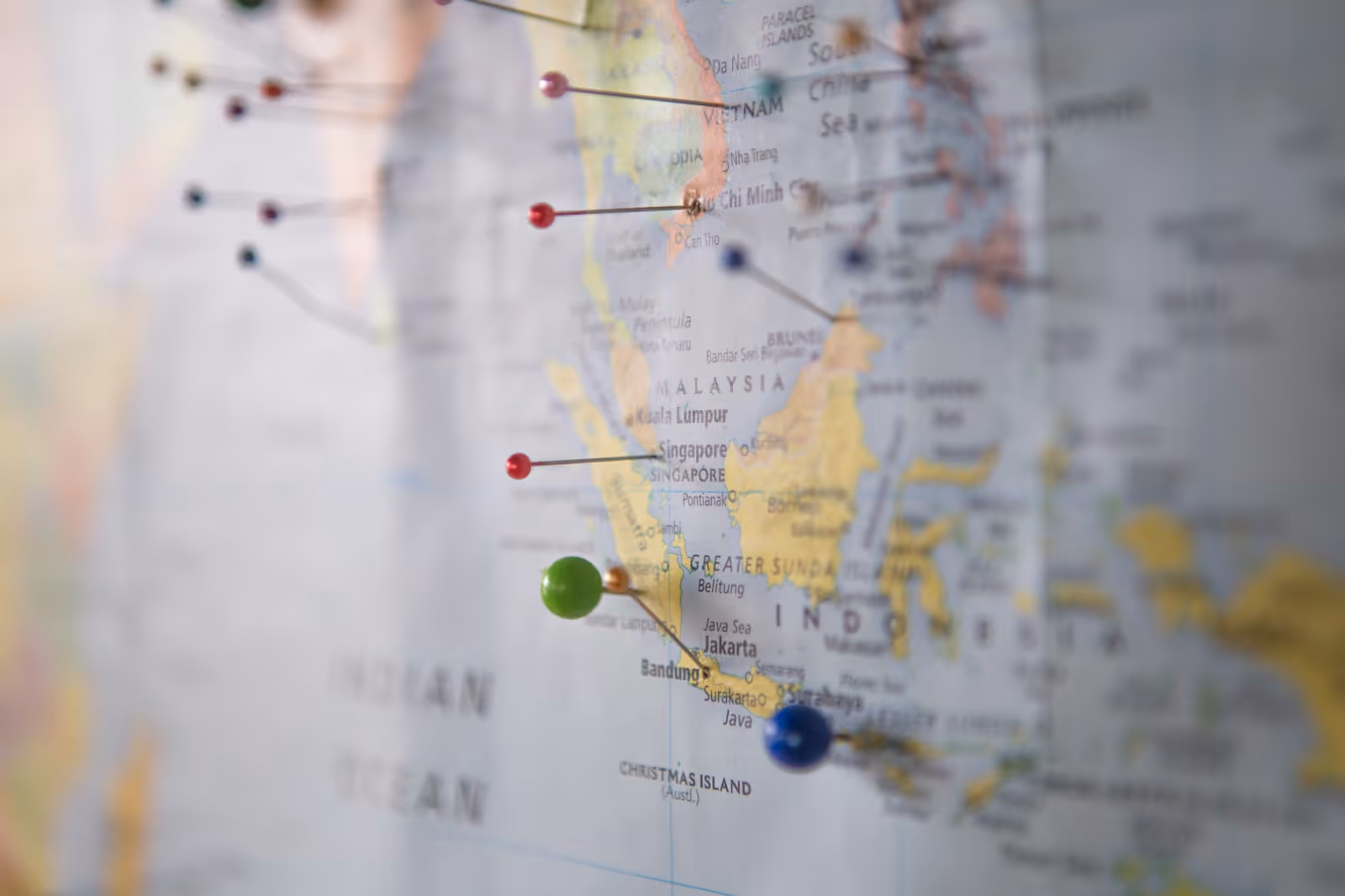 Close up of a map with several pins in it. 
