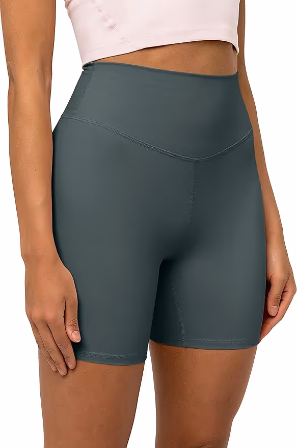 Woman posing while wearing green biker shorts and a sports bra
