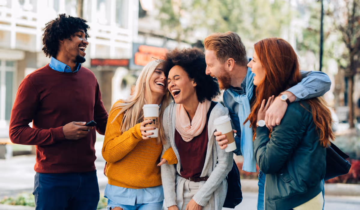 A group of friends who grabbed coffee walking down the streetÂ