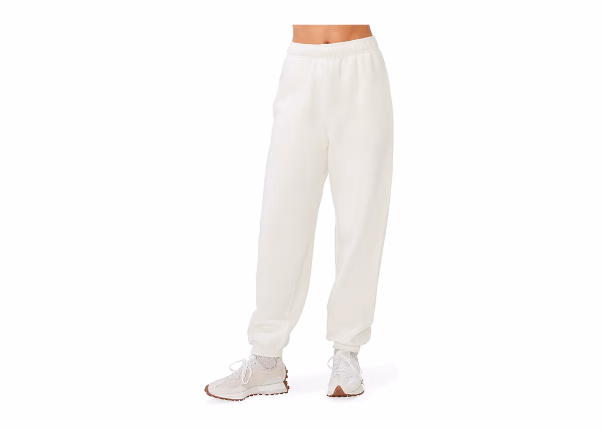 A person wearing white sweatpants and athletic shoes. 