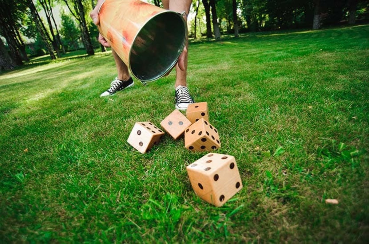 A person dumping out a pail of large wooden dice.