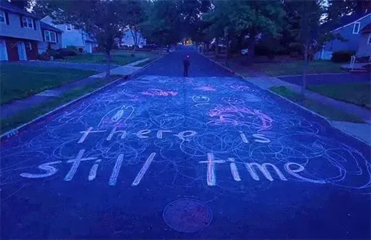 An image from the movie I Saw The TV Glow, displaying chalk art reading “there is still time”.