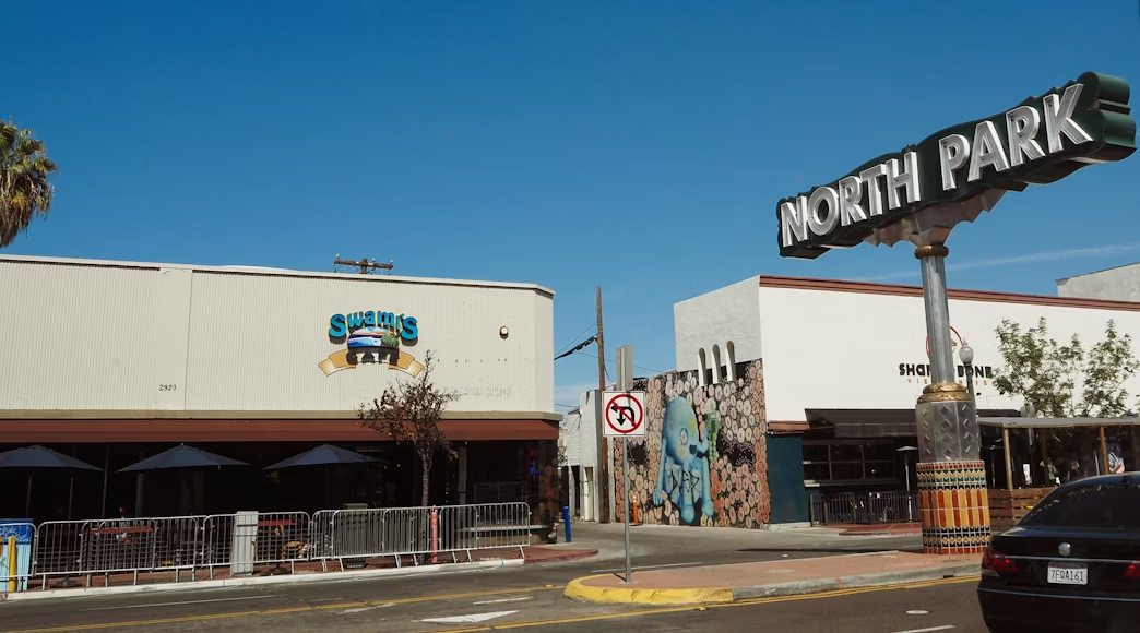 Picture of the North Park sign in San Diego in front of some buildings.