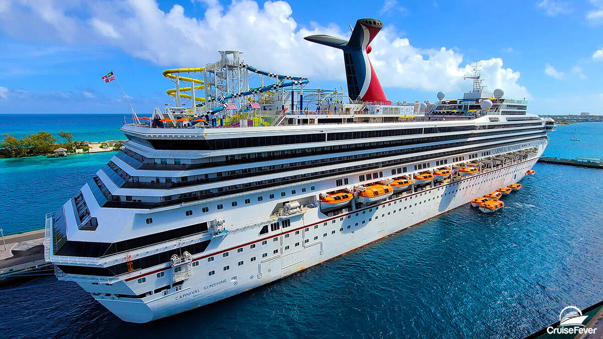 A large Carnival Cruise cruise ship with a water slide on the top deck.