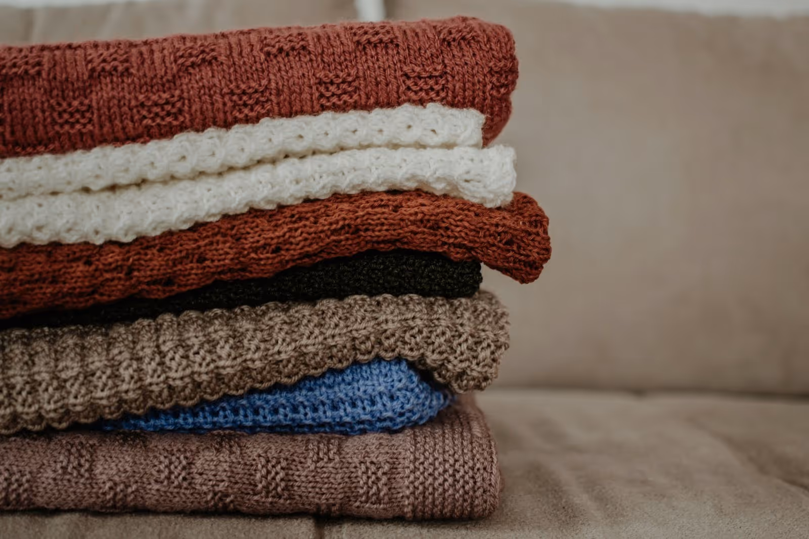 stack of comfortable mens sweaters in different colors and knits