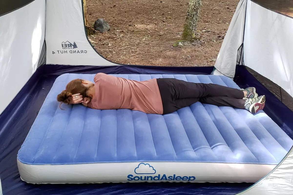 woman sleeping on an inflatable mattress designed specifically for making camping more comfortable 