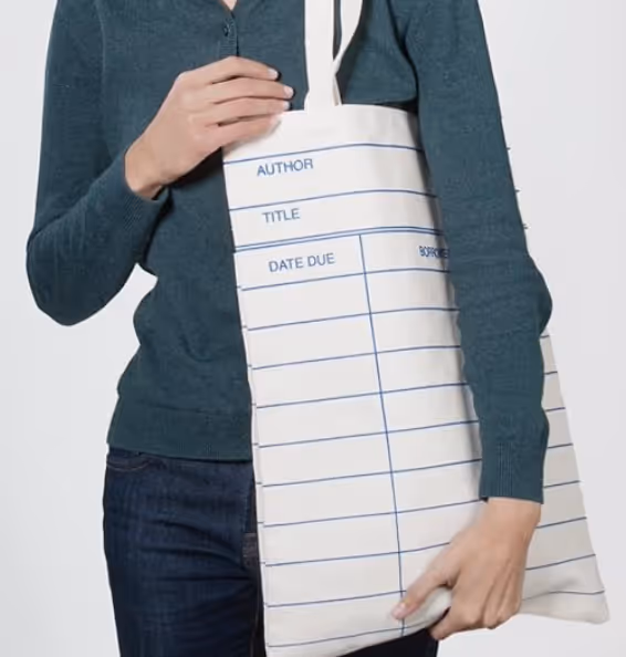 woman holding an out of print library tote bag
