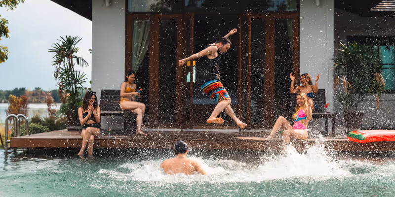 a whole group of friends hanging out poolside because they were able to book an affordable group trip with Priceline