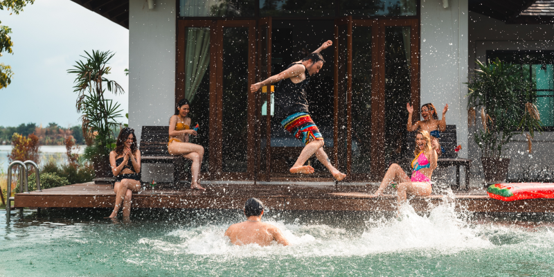 a whole group of friends hanging out poolside because they were able to book an affordable group trip with Priceline