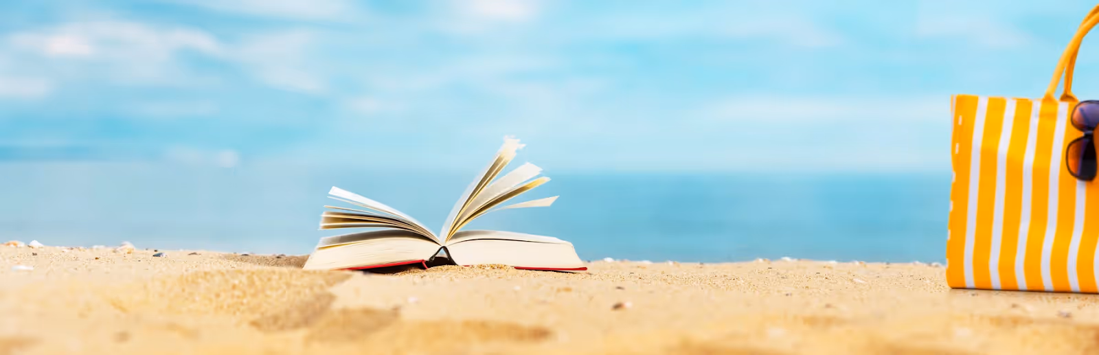 book lying open on a beach thanks to an all-inclusive Apple Vacations 