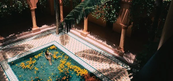 woman reclining in a hotel pool an a vacation she booked with vacation package site Expedia