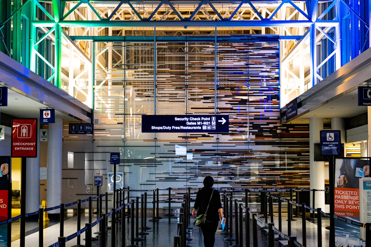 lone traveler making their way toward the security checkpoint at the airport