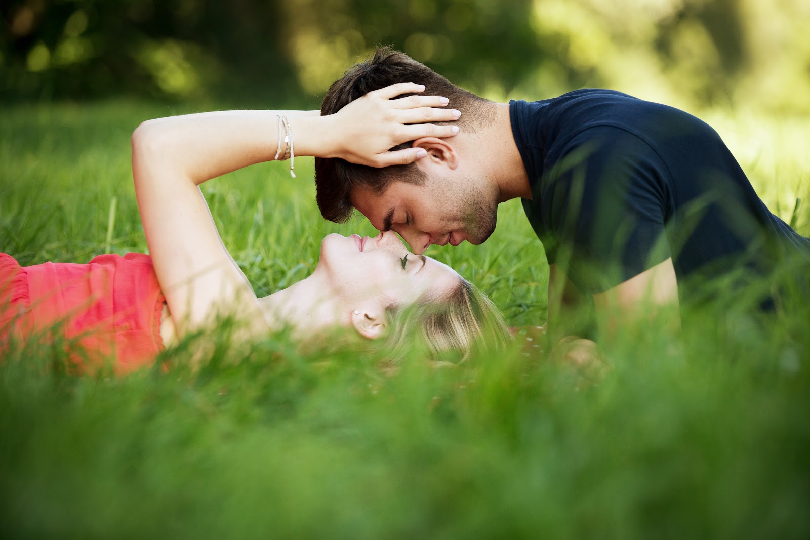 Man and woman lying in the gras with their faces close to one another