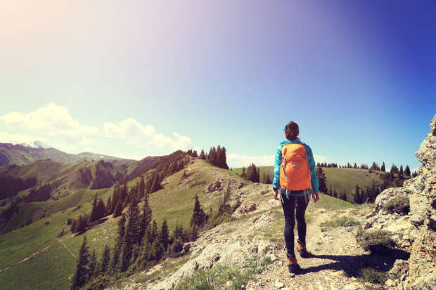 young woman on a scenic hike while learning to travel alone for the first time