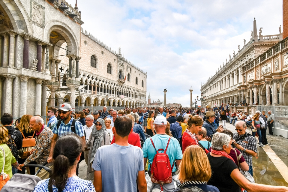 Travelers crowd the square in front of the Doge's Palace in Venice