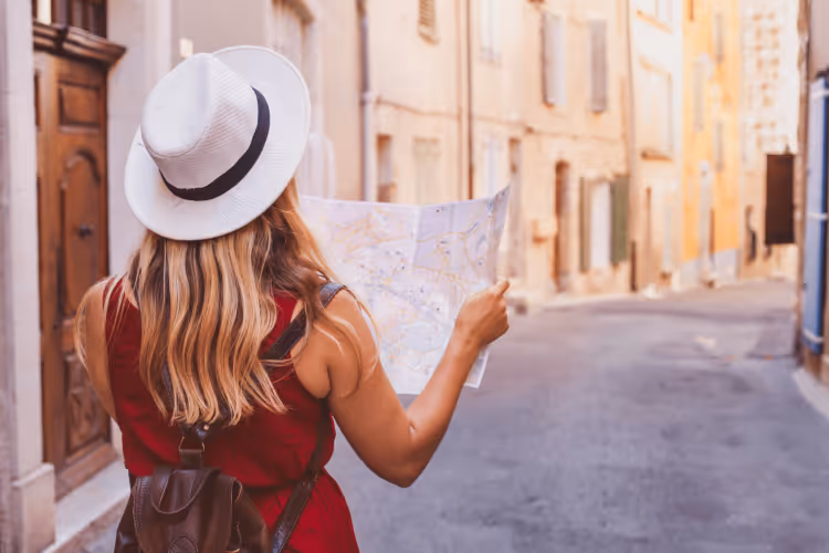 first-time traveler holding a map open as she explores the streets of a historic European city