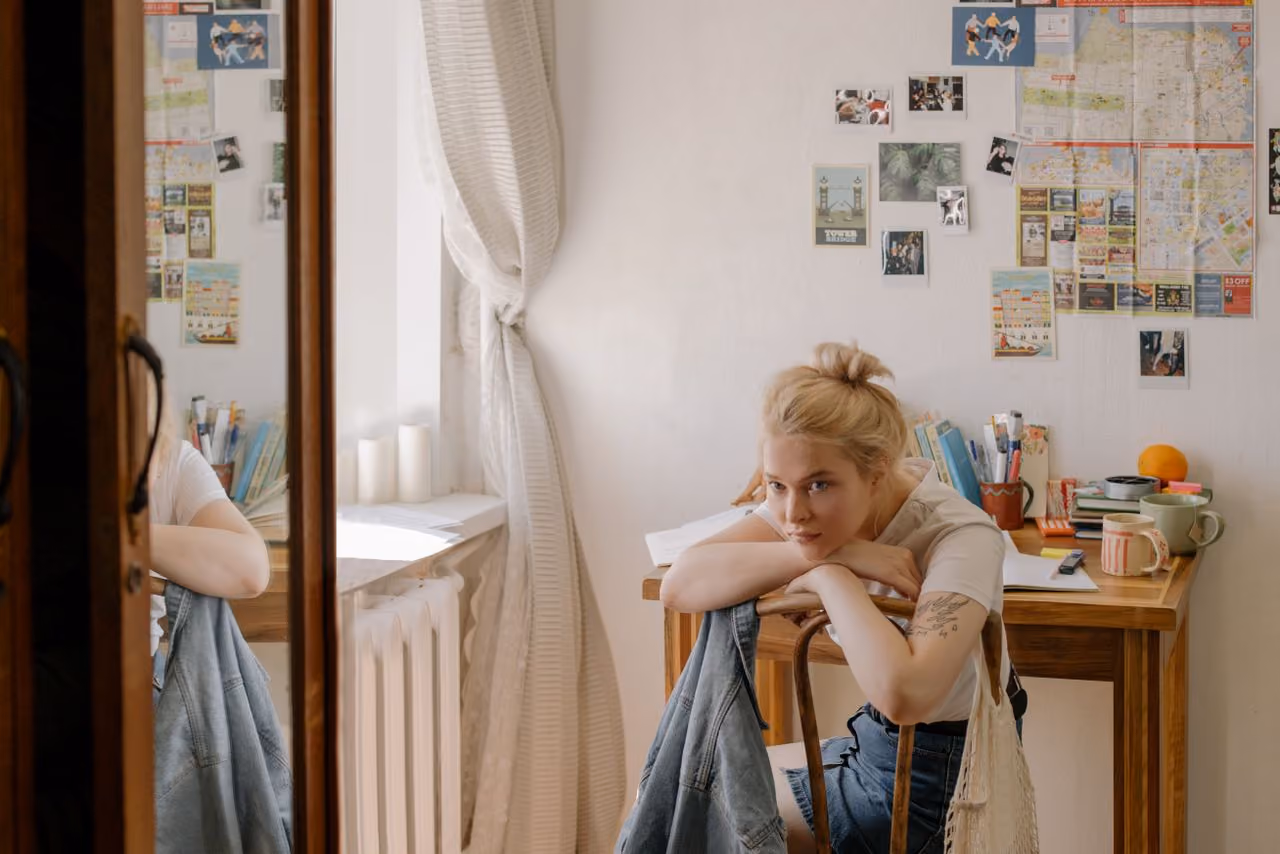 college student seated at her small but well organized dorm room desk