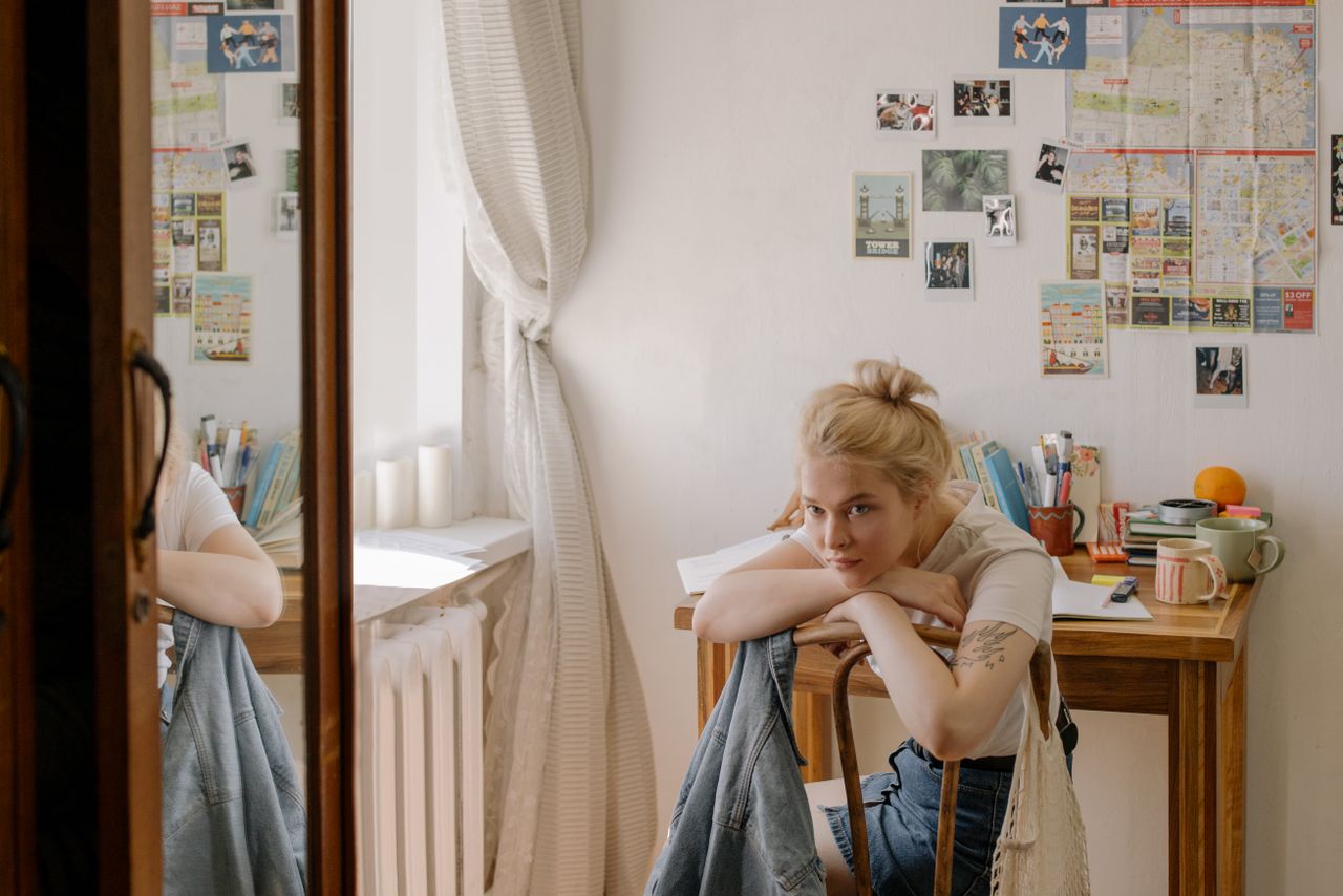 college student seated at her small but well organized dorm room desk