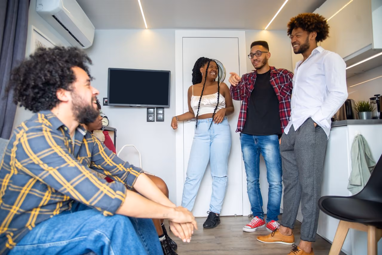 group of college students crowded into one dorm room