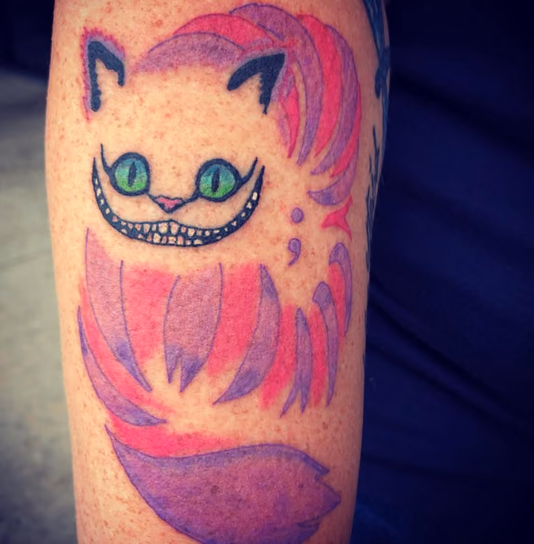 subtle semicolon tattoo hidden inside a larger cheshire cat piece