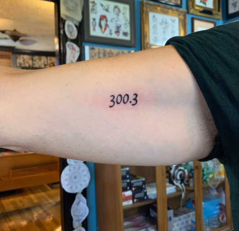 upper arm tattooed with 300.3 the DSM diagnostic code for OCD