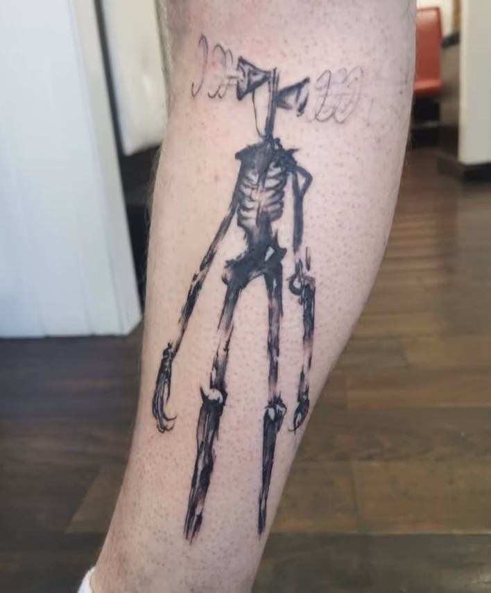horror tattoo of a ghoulish figure with sirens where his head should be