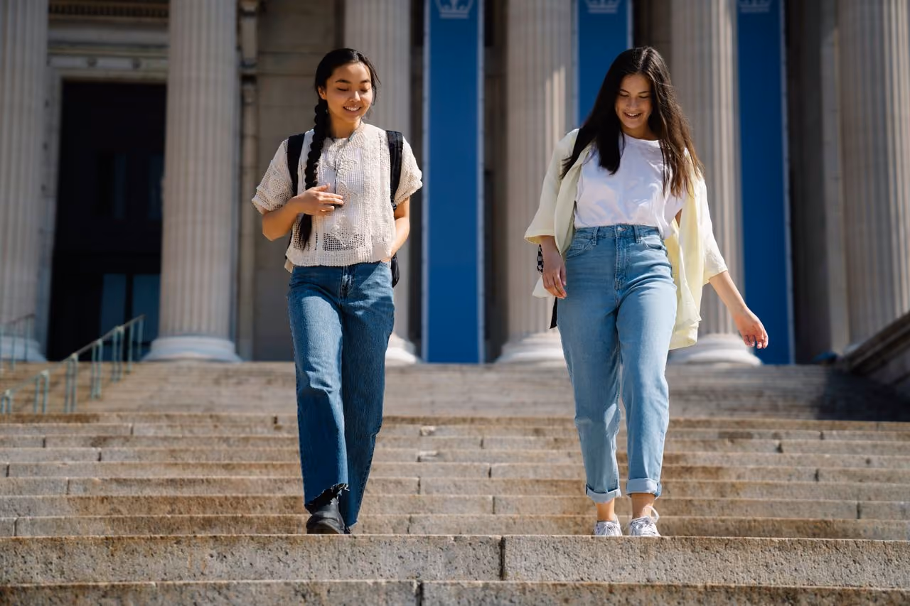 two college students smiling on their campus because they knew what to do the summer before college to get ready