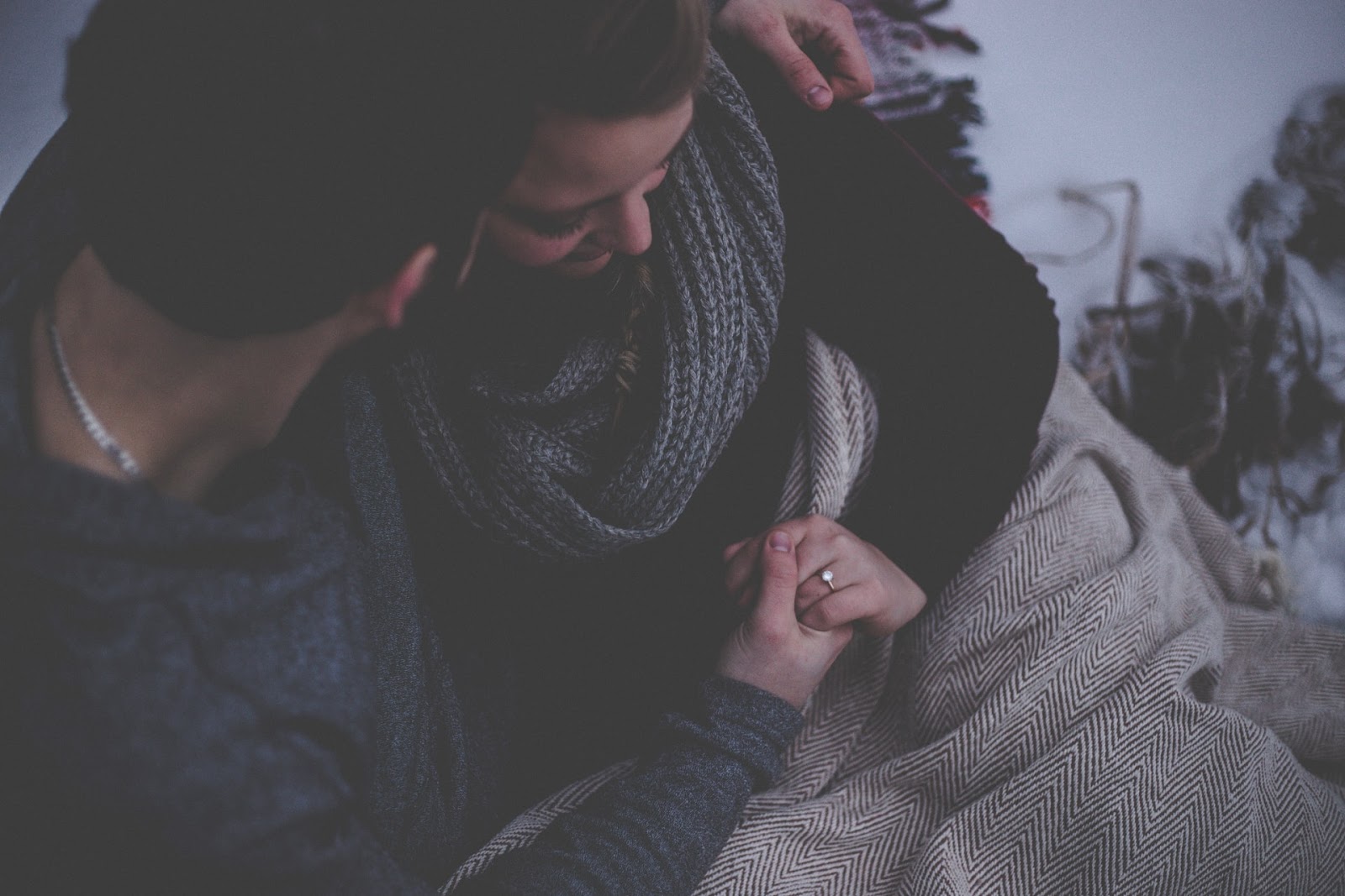 A couple cuddling on a couch.