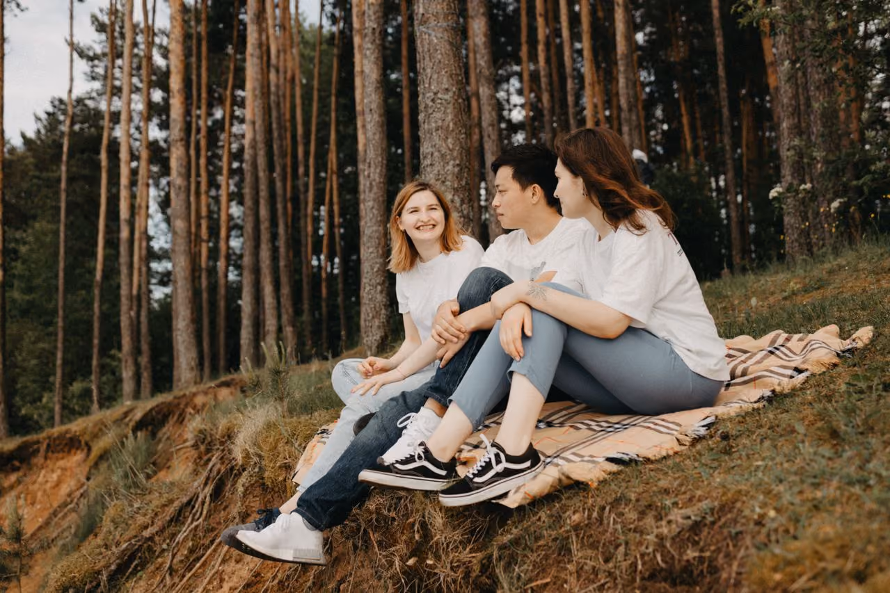 college freshman making friends sitting on a blanket together having a chat on campus