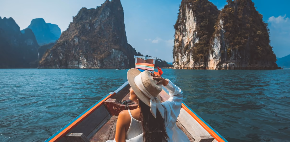 a woman exploring thailand's beaches by boat, an excellent destination for first-time solo female travelers