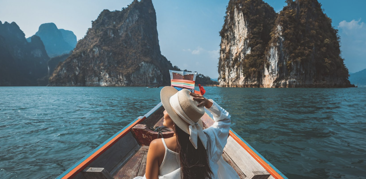 a woman exploring thailand's beaches by boat, an excellent destination for first-time solo female travelers