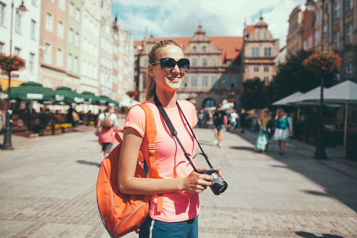 woman with a camera standing on the streets of a European city