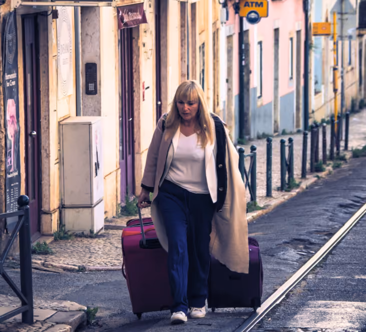 woman dragging her suitcases behind her as she approaches her hotel on her first-time travel to europe