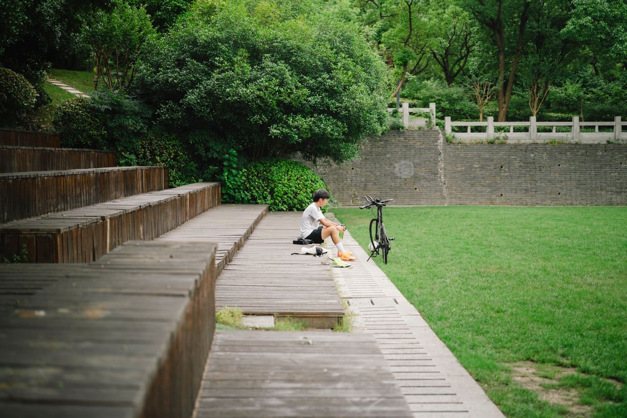 man on a solo bike ride taking a rest, appreciating his new city on his own