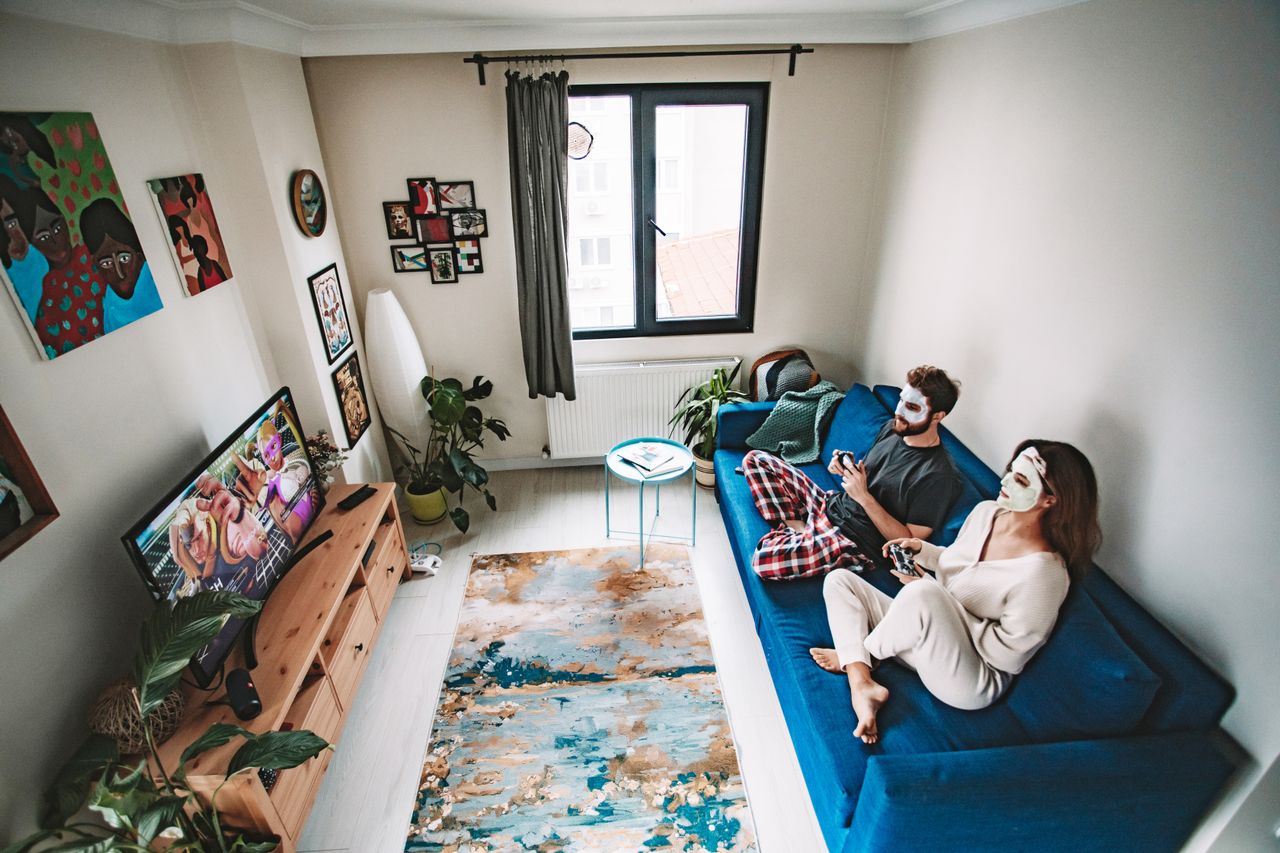 couple enjoying the quiet moments of living together, playing video games and doing a sheet mask after the proverbial relocation dust has settled
