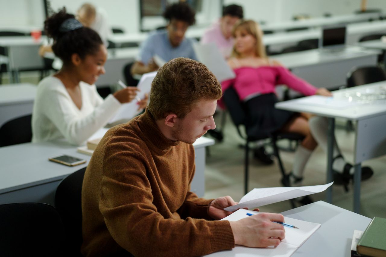 students in lecture figuring out how to take notes in college that will actually help them get good grades