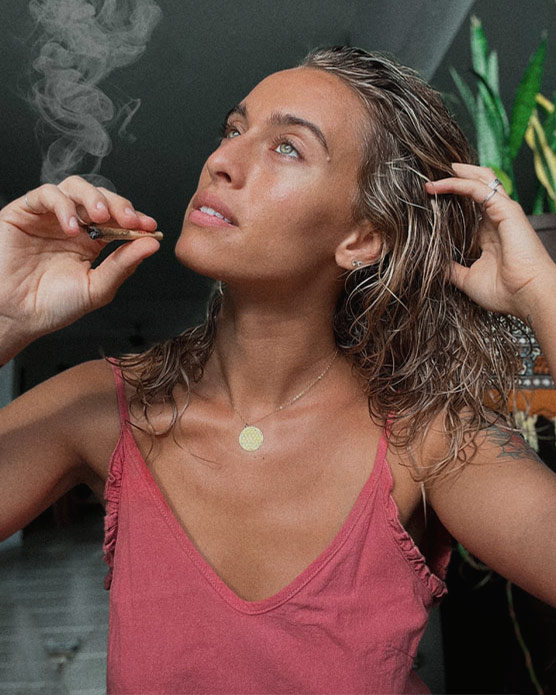 Bailey Rushlow smoking marijuana outdoors, featuring her striking blue eyes and effortless, natural look